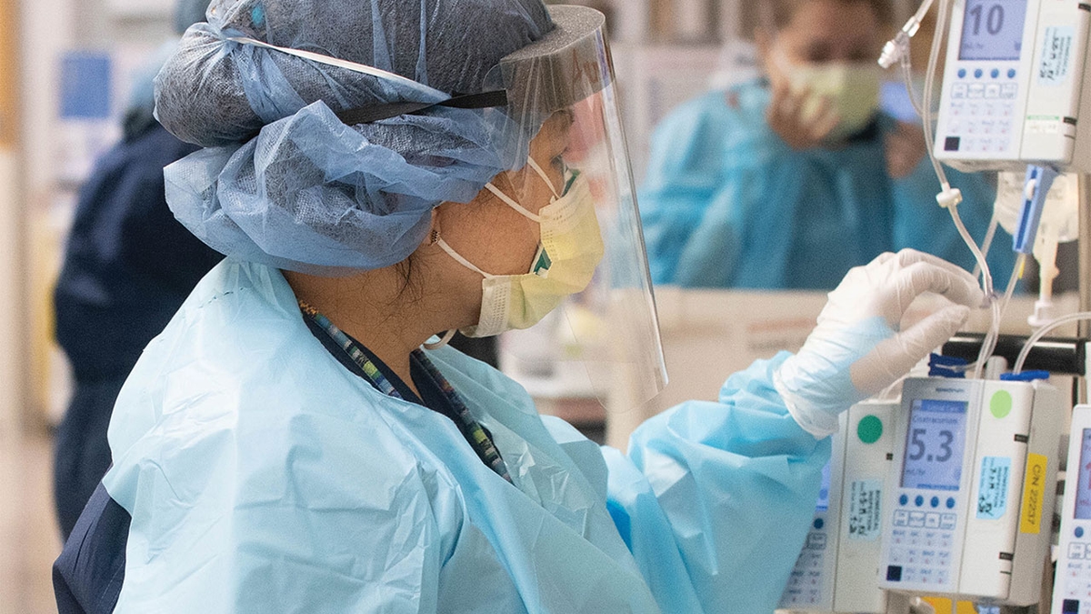 woman with face mask using IV pump