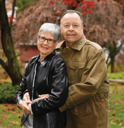 man in brown jacket holding his wife who is wearing a black jacket