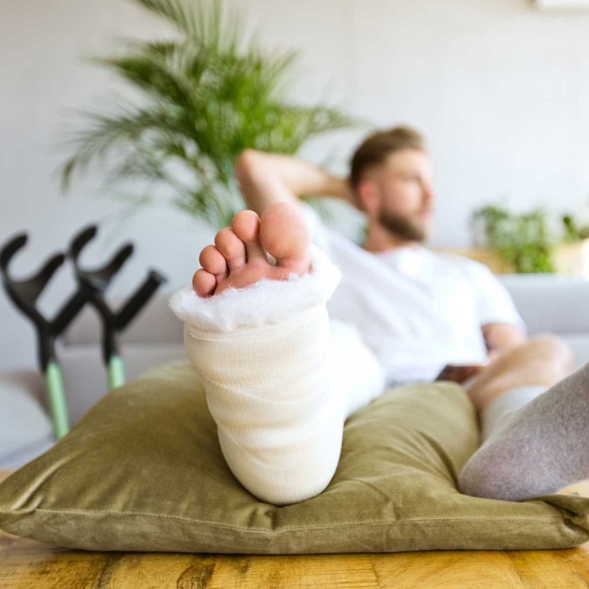 man in bed with broken leg in cast