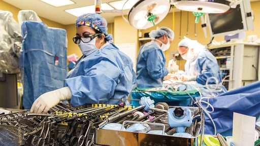 OR room with providers performing surgery using robotic tools