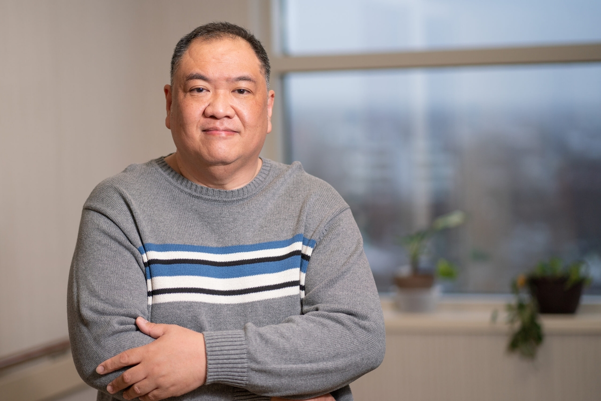 middle aged man with dark hair and gray sweater